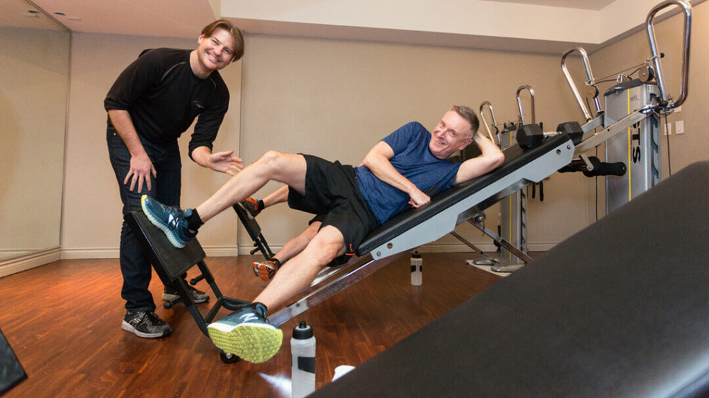 How to achieve a fit body with personal training in Yaletown? Troy smiling while his client poses